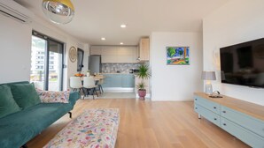 A modern apartment with a living room, kitchen, and dining area.