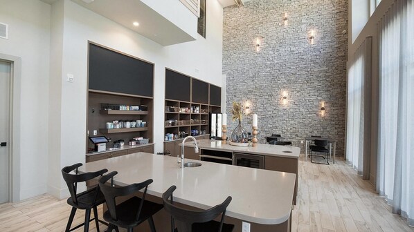 A spacious kitchen with a central island, built-in shelves, and a stone accent wall.