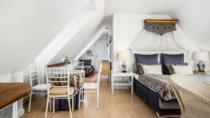 Un dormitorio con cama, una silla, una mesa y una escalera.