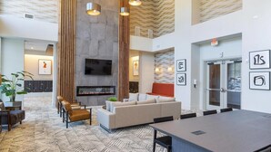 Eine moderne Hotelhalle mit Kamin, Sitzgruppe und Konferenztisch.