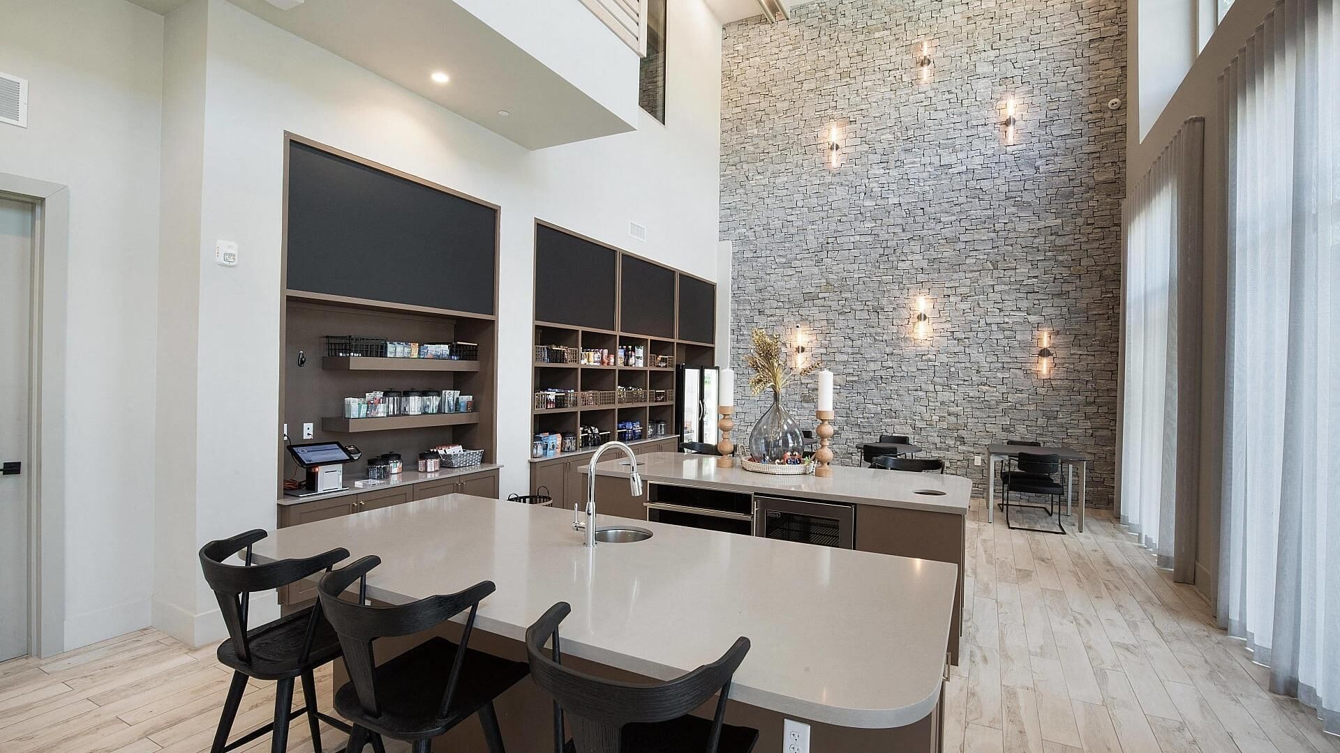 A spacious kitchen with a central island, built-in shelves, and a stone accent wall.