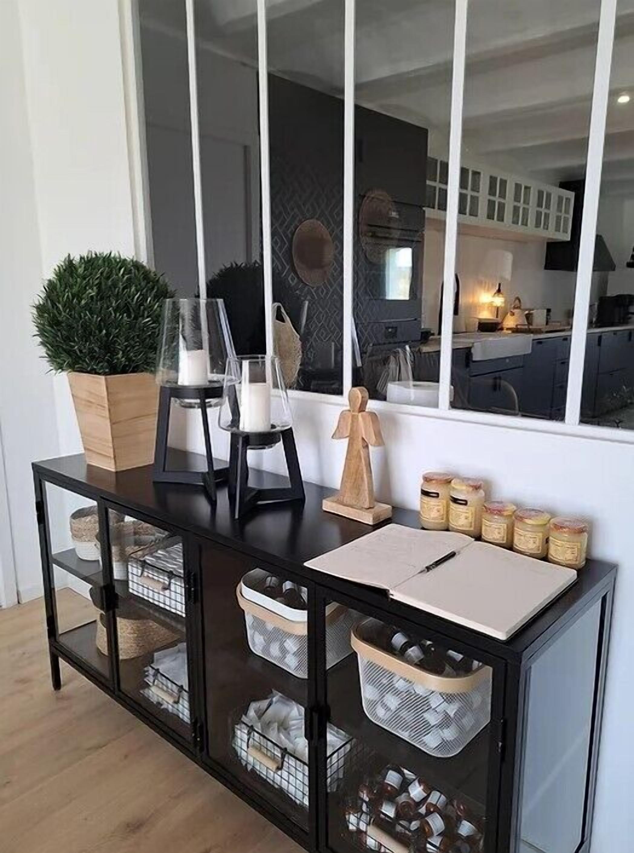 A modern kitchen with white cabinets, a black countertop, and a large window.
