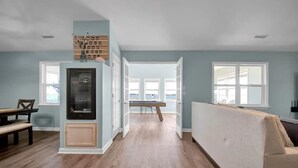 Ein geräumiges Wohnzimmer mit Holzboden, einem Essbereich mit Tisch und Stühlen sowie einem großen Fenster mit Aussicht.