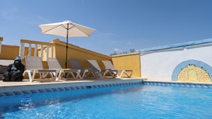 A pool area with lounge chairs and an umbrella. - Casa Rosa: Long-term Living & Workspace (Valencia)