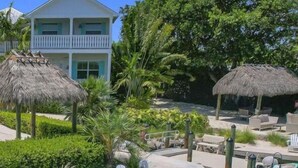 A resort with a pool area, lounge chairs, and a building with a balcony. - Isla Guava: Boutique Resort, FREE Boat Dockage Sept-Oct Only! (Islamorada)