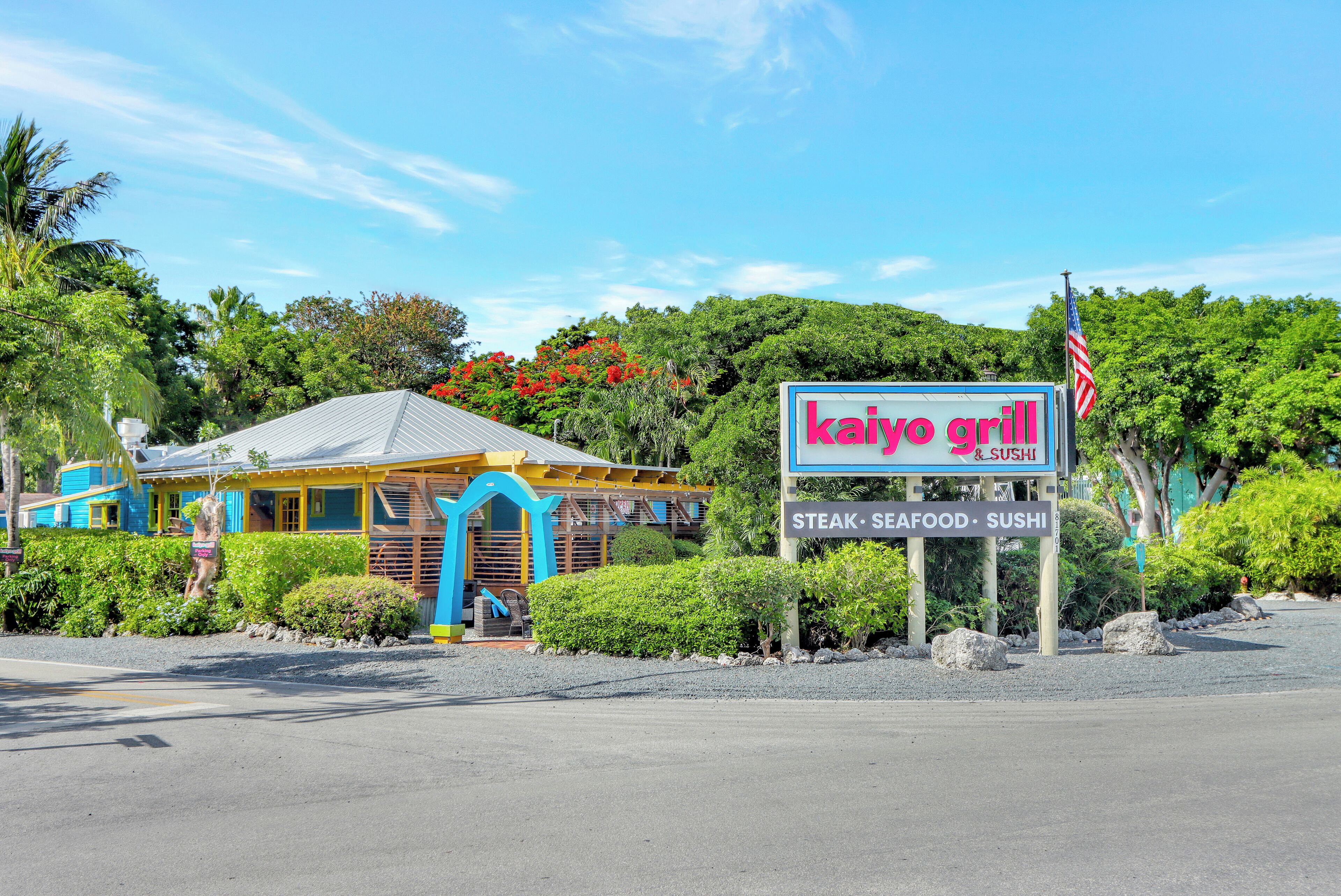 Un restaurante llamado Kaiyo Grill con un letrero que indica que sirve carne, mariscos y sushi.