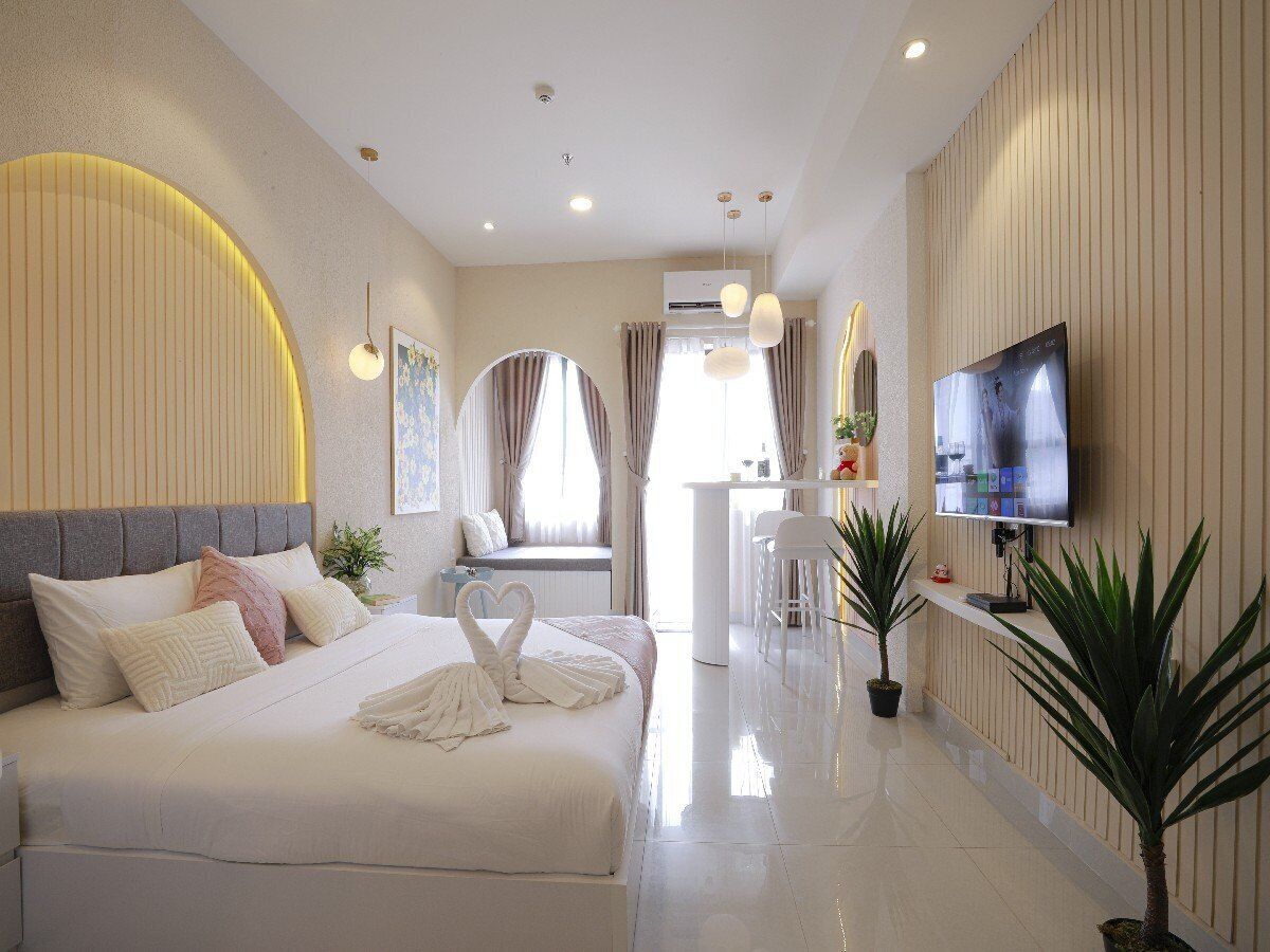 Une chambre d’hôtel moderne équipée d’un grand lit, d’un bureau, d’une télévision et d’une salle de bain.