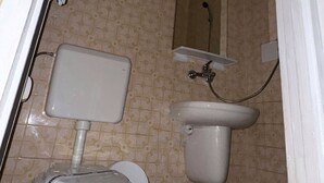 A small bathroom with a toilet, sink, and mirror. - Legacy Hotel (Eforie)