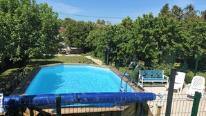 A rectangular swimming pool surrounded by a wooden deck and a metal fence. - La Maison Glycine. A charming 3 bedroom cottage set in beautiful countryside  (La Villedieu)