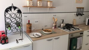 A kitchen with a wine rack, a stove, a microwave, and a sink. - La Maison Glycine. A charming 3 bedroom cottage set in beautiful countryside  (La Villedieu)