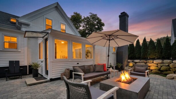 A patio with a fire pit, outdoor furniture, and a stone wall. - Stylish Cape Escape on Bank St RPAM070 (Harwich)