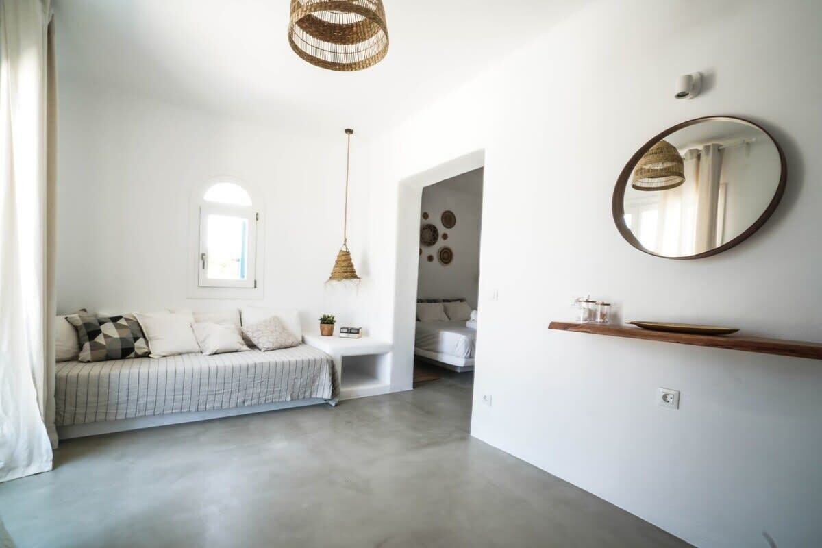 Une chambre à coucher moderne avec un lit, une table de chevet et un miroir au mur.