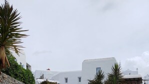 Una scala in pietra conduce a un edificio bianco, con un muro in pietra a sinistra.