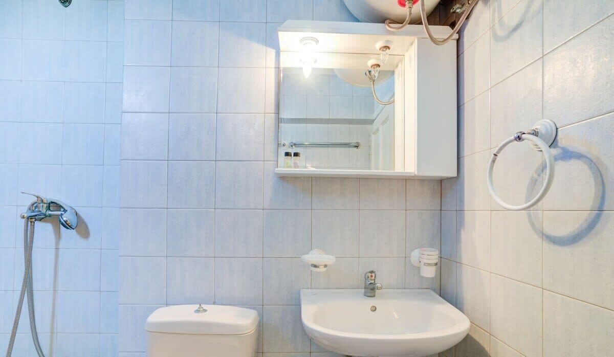 A bathroom with a toilet, sink, and shower.