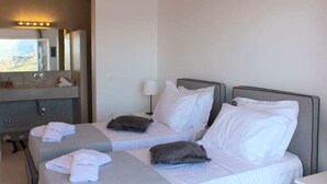 A hotel room with two beds, a large mirror, a vanity with a sink, and towels on the beds. - Mykonian Luxury Light Blue Villa with Private Pool (Mykonos)