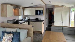 A compact living space with a kitchenette, a sofa, and a dining table.