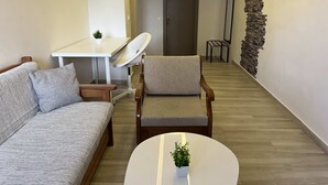 Un salon moderne avec un canapé, un fauteuil et une petite table sur laquelle est posée une plante.
