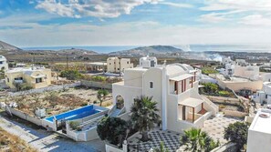 A residential area with modern architecture, a swimming pool, and a view of the sea. - Modern Naya Escape in Santorini with Captivating Sea Views (Santorini)