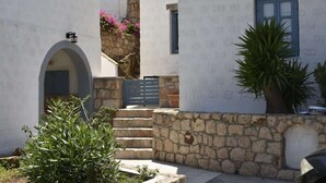 A narrow stone staircase leading to a white building with a blue window and a door. - Relaxing Patmos Studio by the Aegean No 2 (Patmos)