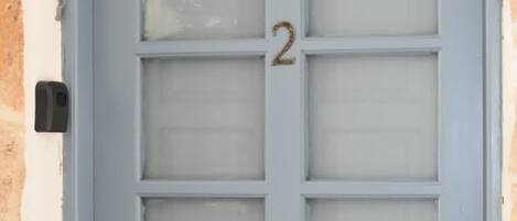 A light blue door with a number '2' and frosted glass panels.
