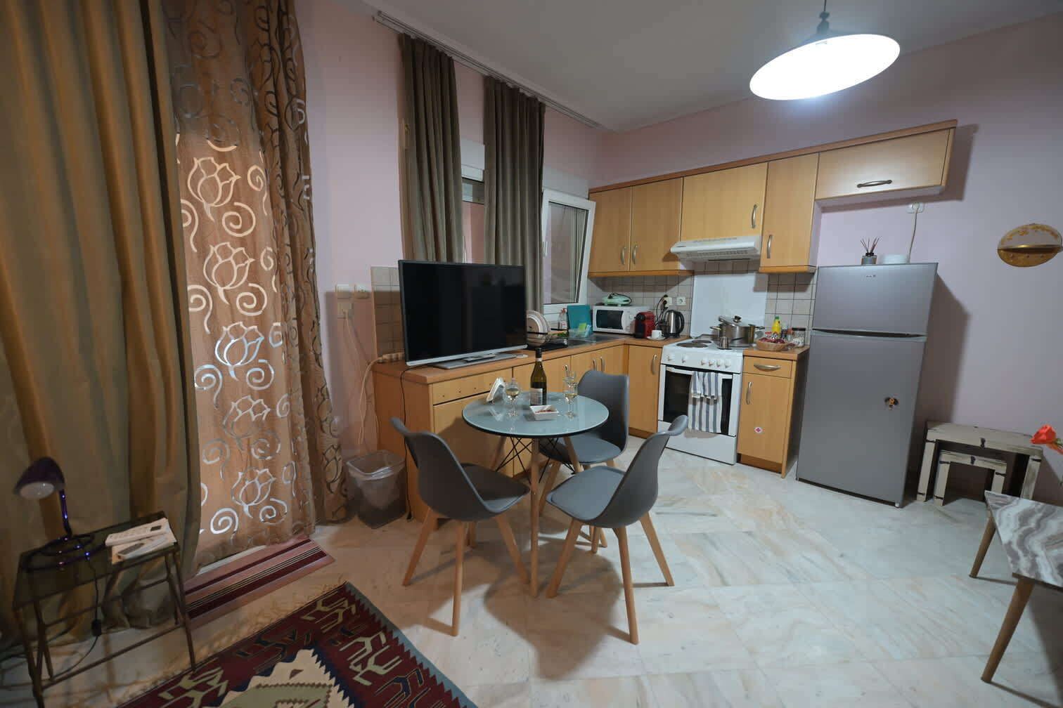 Un espace de vie compact comprenant un coin repas, une kitchenette et un téléviseur.
