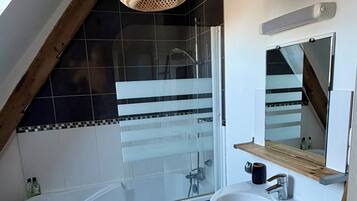 Een moderne badkamer met een bad, een wastafel en een douche.