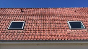 A house with a red-tiled roof, two skylights, a wooden door, and two wicker chairs outside. - Les Buissonnets - Maison de Campagne à 10 Minutes de la Plage de Wissant (Peuplingues)