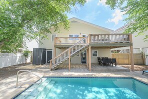 A residential backyard with a swimming pool, a wooden deck, and a staircase leading to an upper level. - 5 BR Walk to the Beach House with a Private Pool! The Salty Seagull (Surfside Beach)