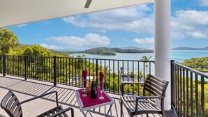 A balcony with a table, chairs, and a bottle of champagne. - Panorama at Shute Harbour (Shute Harbour)