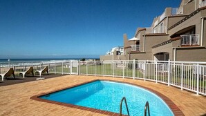 A swimming pool with a wooden deck, white railings, and a view of the ocean. - Stunning ocean vistas, near top surf spots, shops; private, all amenities. (Jeffreys Bay)
