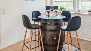 A round table with a glass top, four black chairs, and a wooden barrel base. - 3 bedroom awesome home in Ebeltoft (Ebeltoft)