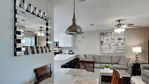 Una sala moderna con comedor, cocina y ventilador de techo.