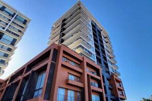 A high-rise building with multiple balconies and large windows.