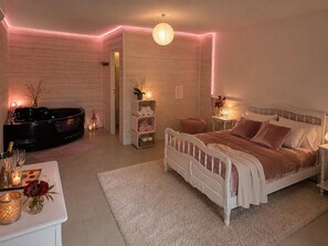 Une chambre à coucher avec un lit, une table de chevet et une baignoire.