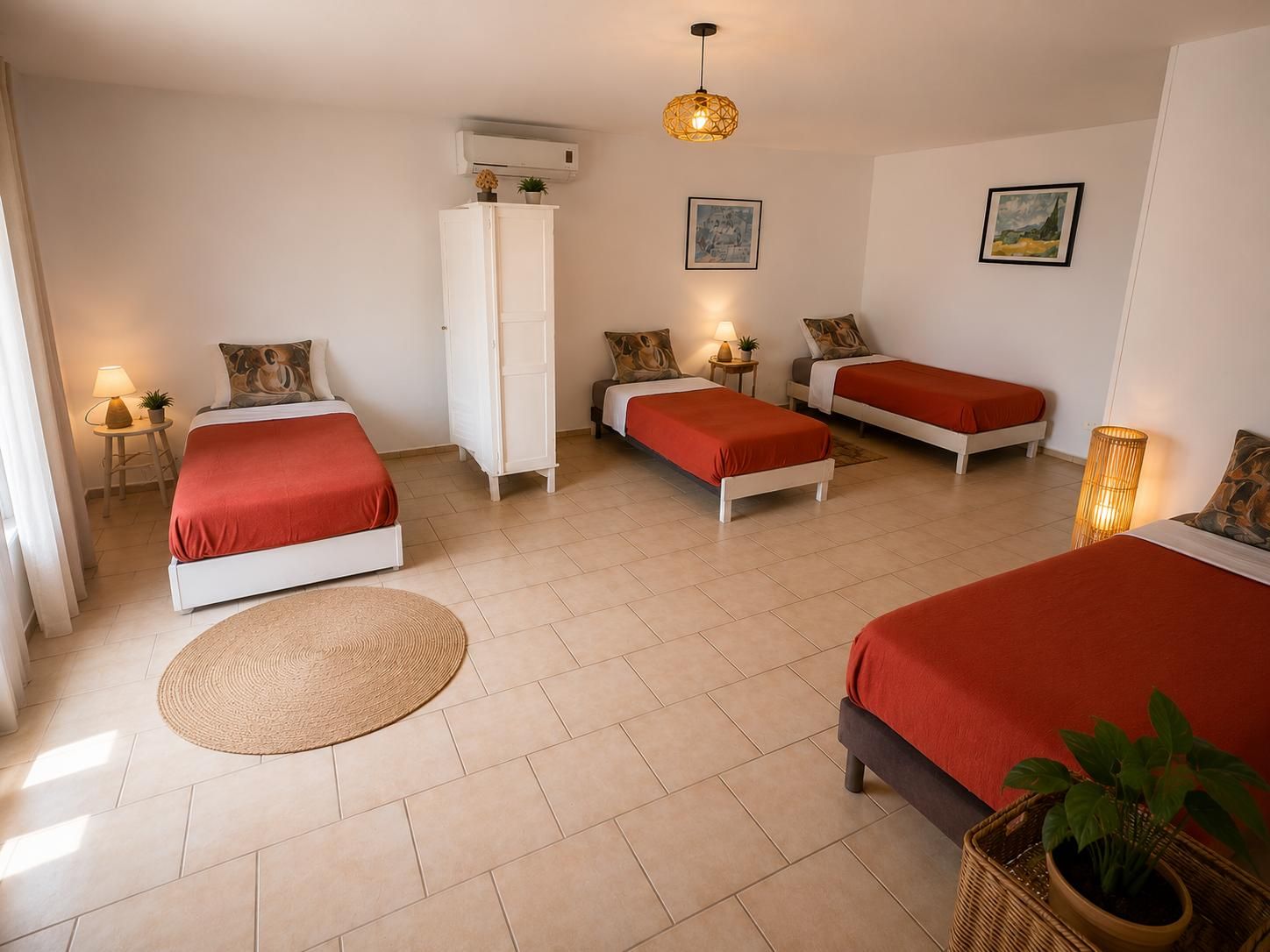 Una habitación de hotel con tres camas, un armario blanco, un tapete redondo y una lámpara en el techo.