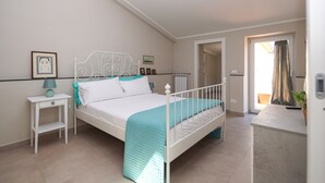Un dormitorio con cama, mesita de noche y vista al exterior.