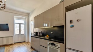 Una cocina moderna con horno empotrado, cafetera y refrigerador.
