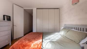 A bedroom with a bed, a dresser, and a wardrobe.