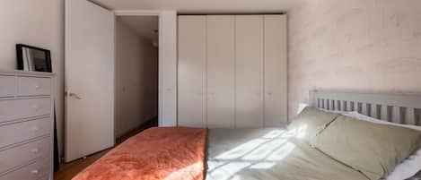 A bedroom with a bed, a dresser, and a wardrobe.