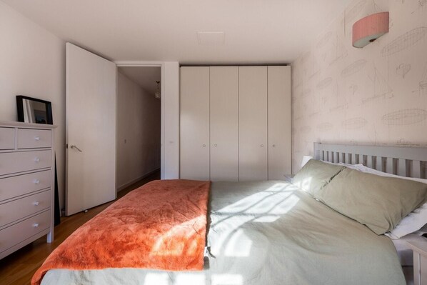 Un dormitorio con cama, cómoda y armario.