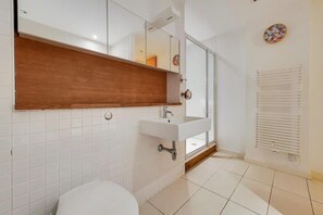 Appartement | Badkamer | Een aparte badkuip en douche, een diep bad, een haardroger, handdoeken