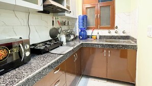Una cocina con encimeras de granito, electrodomésticos de acero inoxidable y armarios de madera.