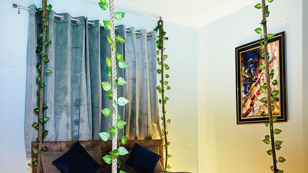 Un dormitorio con cama, cortinas, ventilador de techo y un cuadro en la pared.