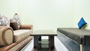 Una sala de estar con un sofá, una mesa de centro y un diván.