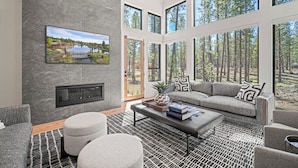 Una sala de estar moderna con chimenea, ventanas amplias y vistas al exterior.