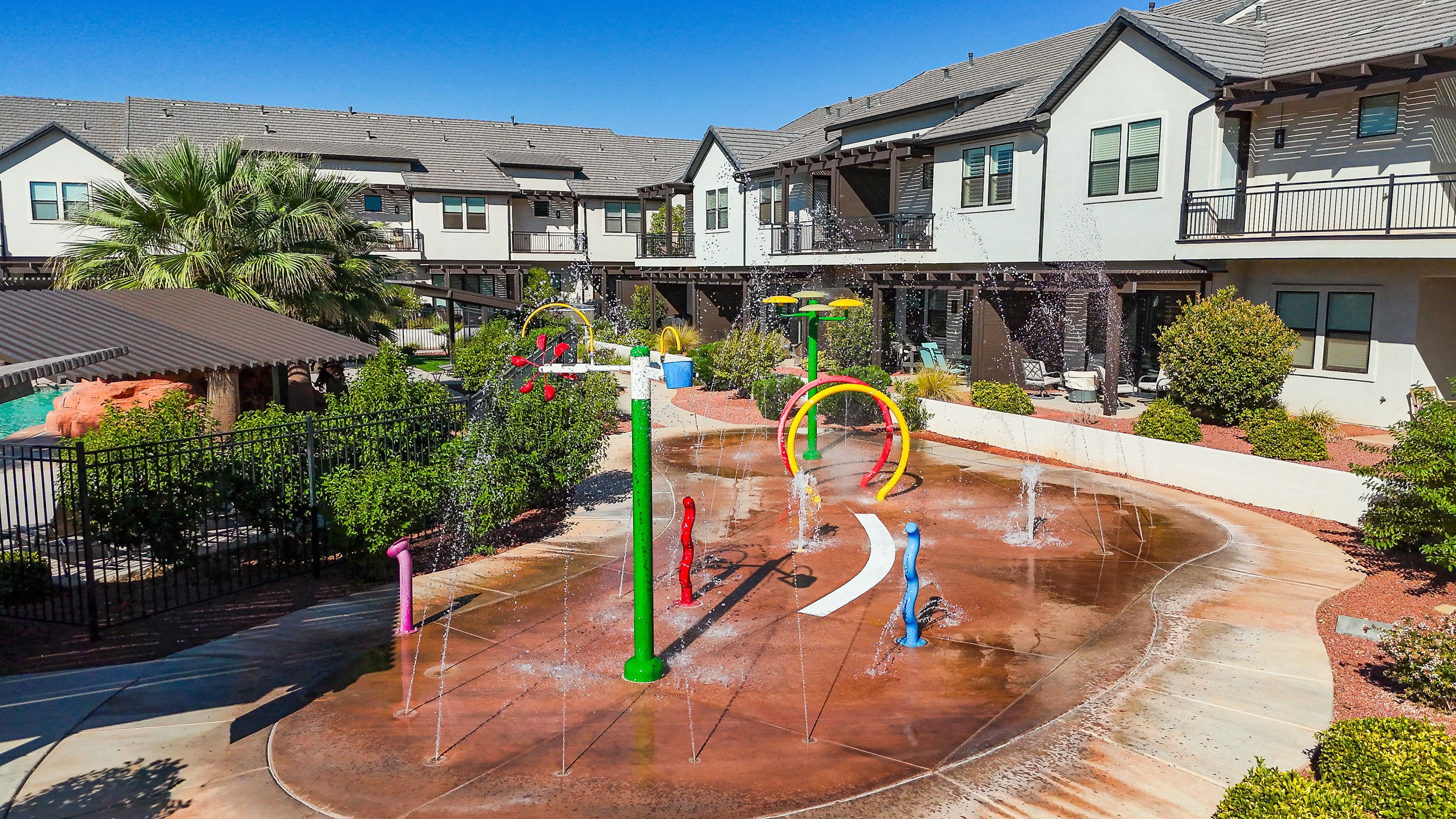 A residential area with houses, a water play area, and a pool.