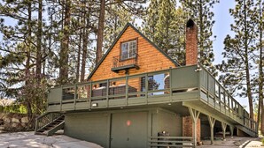 A wooden cabin with a balcony, a covered garage, and a pedestrian bridge. - Modern Big Bear Lake Cabin w/ Lake Access! (Big Bear Lake)