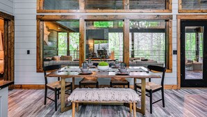 Un espace repas comprenant une table en bois, des chaises et un banc.