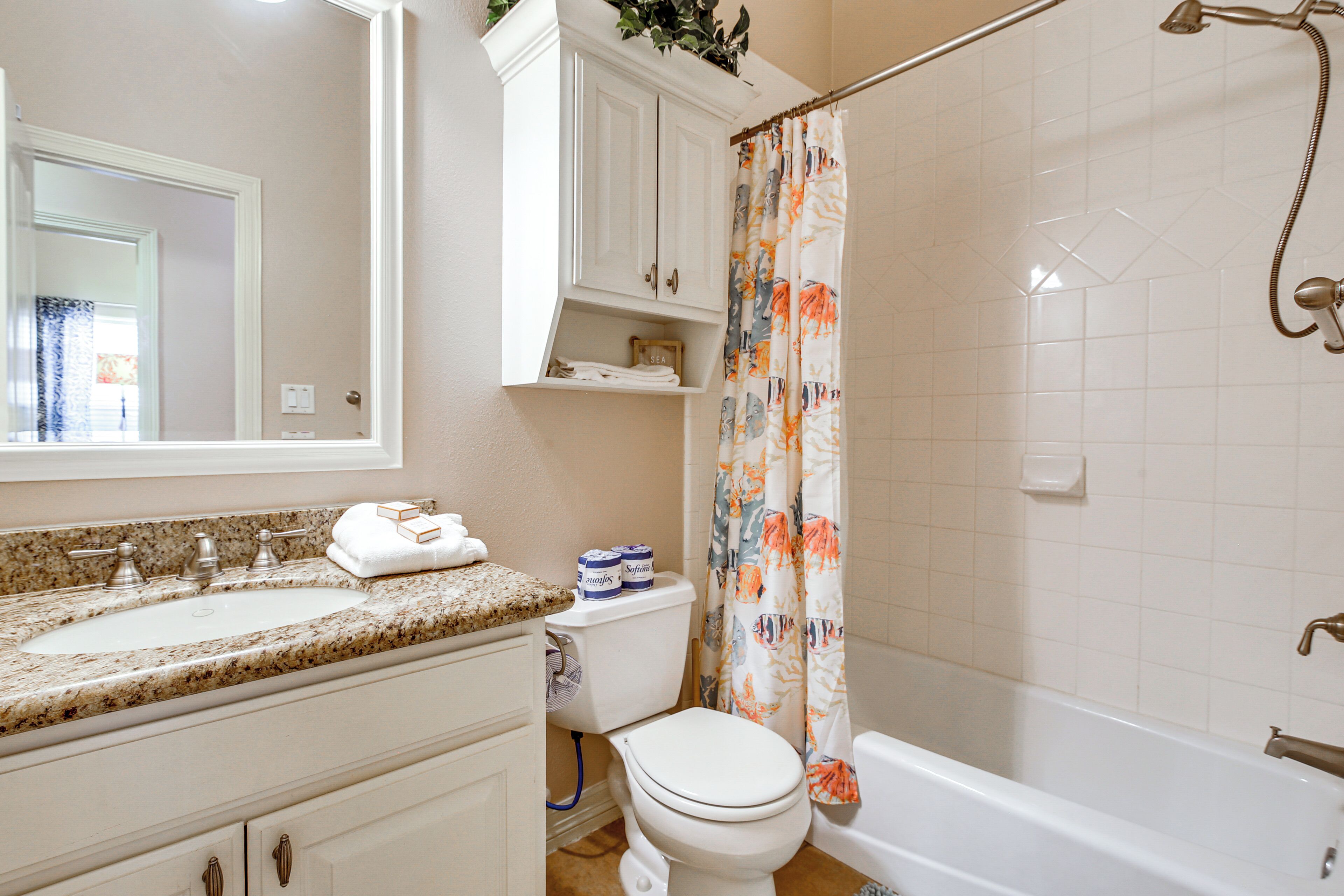 A bathroom with a sink, toilet, and bathtub.