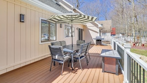 A deck with a table and chairs, a grill, and a covered area with an umbrella. - Spacious Retreat 7 Mi to Tobyhanna State Park! (Tobyhanna)